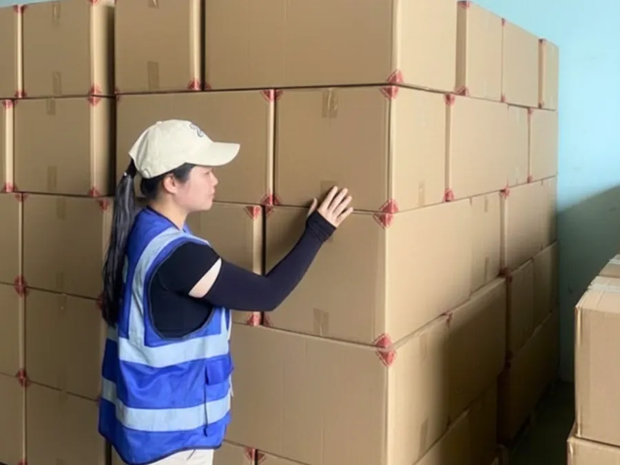 Quality control staff checking a strapped stack of cartons
