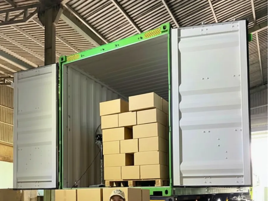 Cartons stacked on a pallet inside an open container at the warehouse